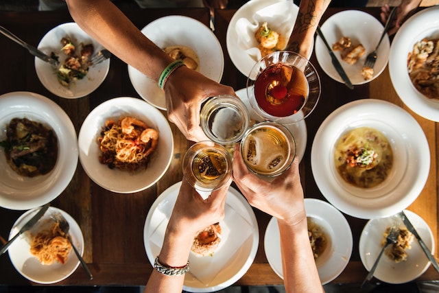 clicking glasses of wine over Chinese foods